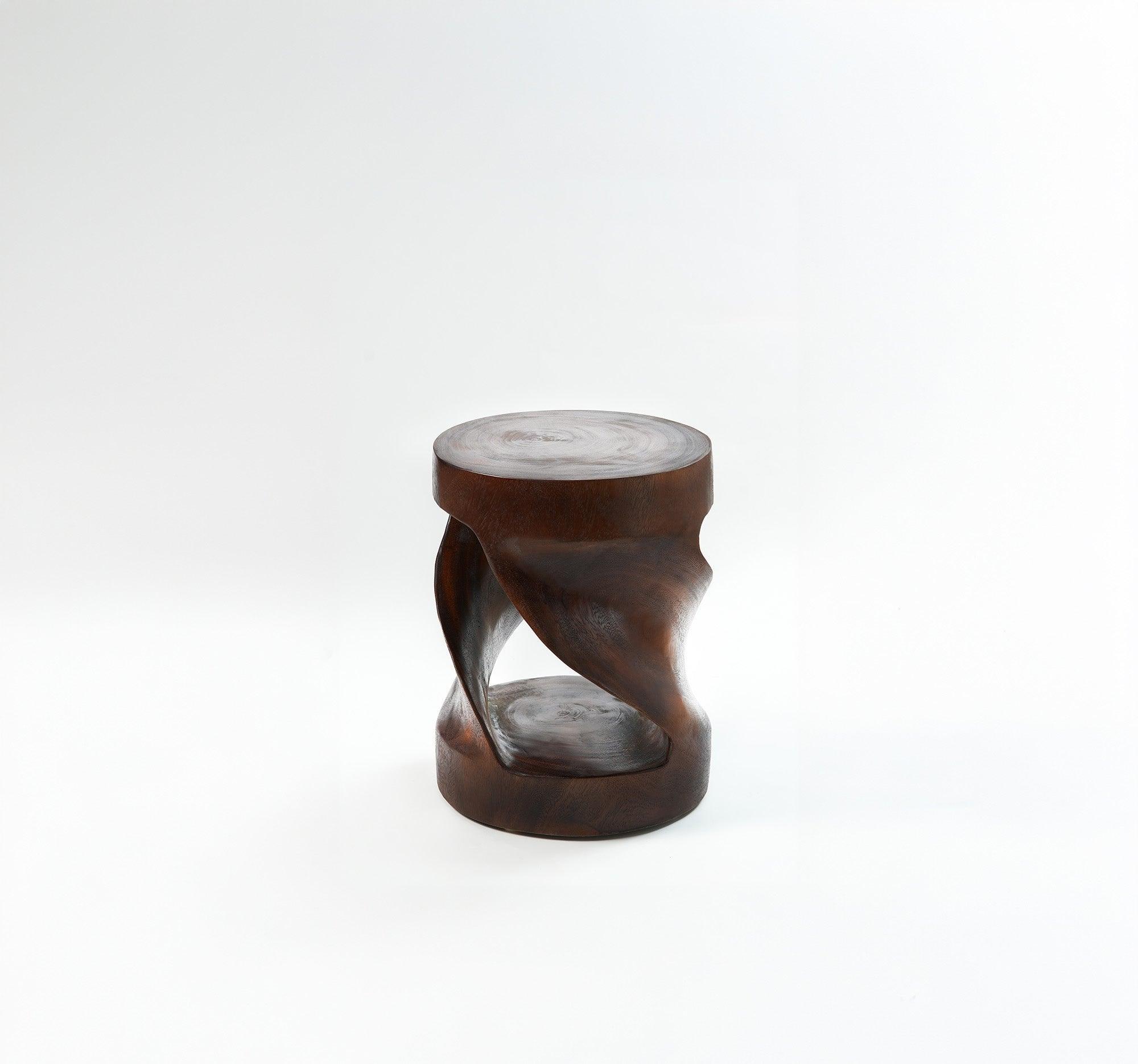 A free-standing stool made from a tree trunk, featuring an organic shape. Perfect for adding a natural touch to any room.